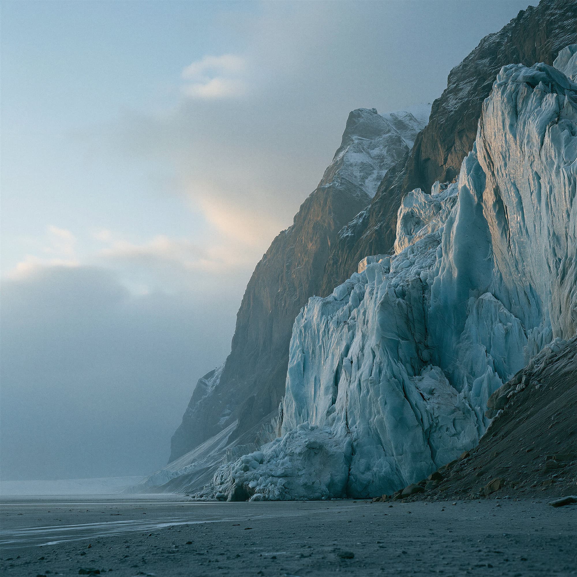Icelandic glacier formations meeting black volcanic sand plains at dawn, simulated landscape photography created with Midjourney, stamped with VISID structured metadata
